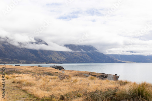 A landscape of a mountain lake, mountains and a winding road in New Zealand.