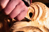 Man is carving a wooden mask. Mann schnitzt eine Holzmaske