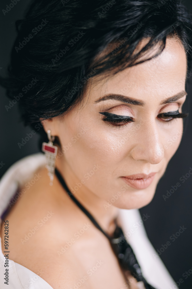 Pensive young woman in white shirt, looking thoughtful and posing for camera in studio
