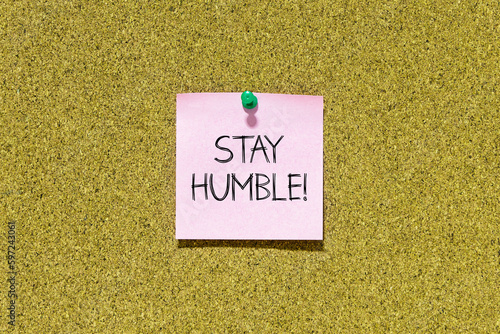 фотографія Stay humble text on pink post-it paper pinned on bulletin cork board