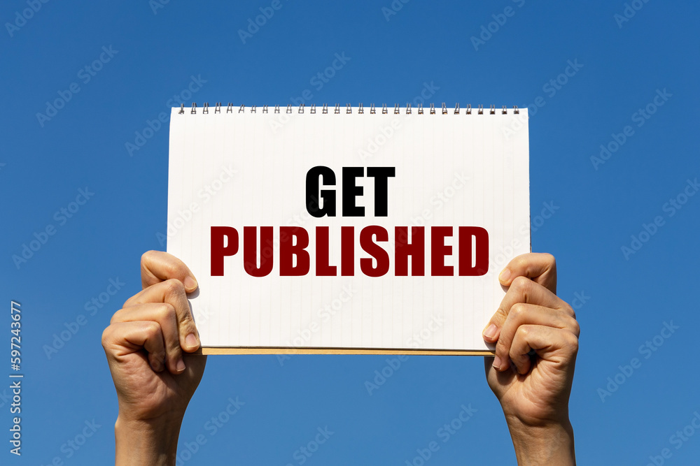 Get published text on notebook paper held by 2 hands with isolated blue sky background. This message can be used as business concept about getting published. Get published text on notebook paper held by 2 hands with isolated blue sky background. This message can be used as business concept about getting published.