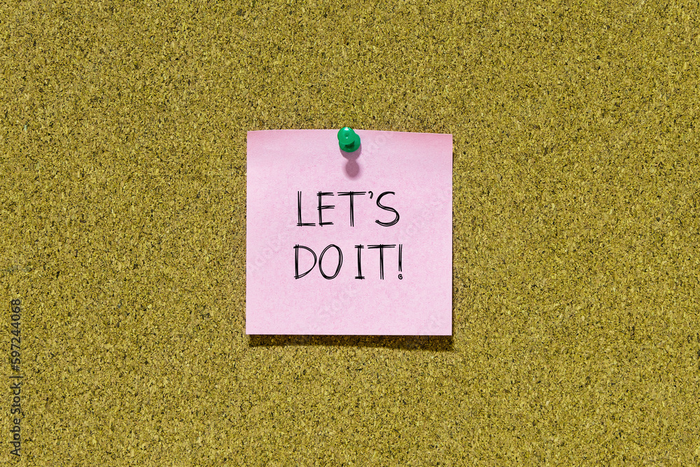 Let's do it text on pink post-it paper pinned on bulletin cork board