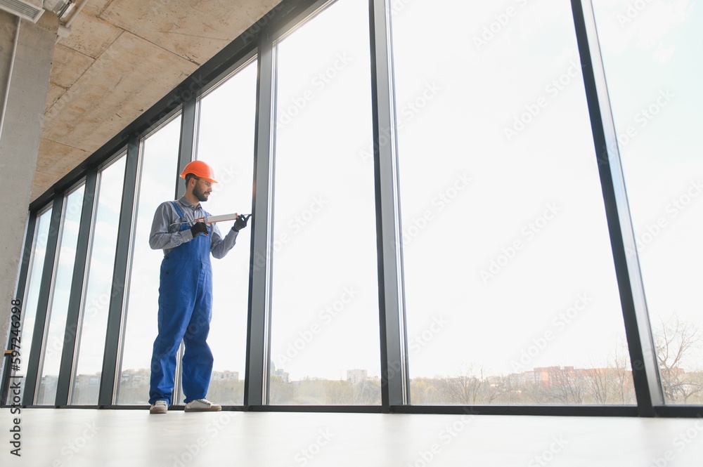 service man installing plastic window. service man installing plastic window.