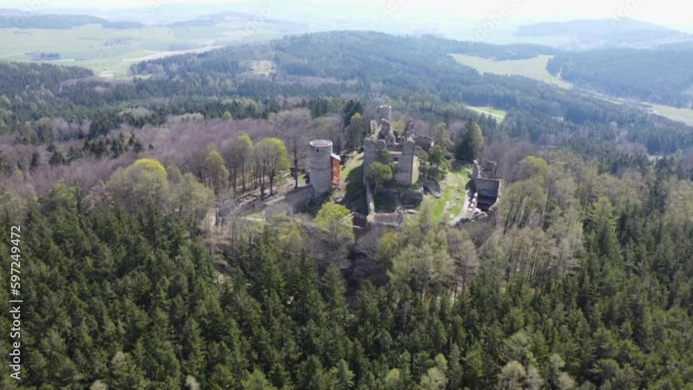 Aerial shot of the castle in the middle of the woods. A ruined castle located on a hill in the middle of the woods. Medieval castle tower Aerial shot of the castle in the middle of the woods. A ruined castle located on a hill in the middle of the woods. Medieval castle tower