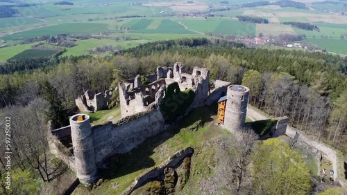 Aerial shot of the castle in the middle of the woods. A ruined castle located on a hill in the middle of the woods. Medieval castle tower