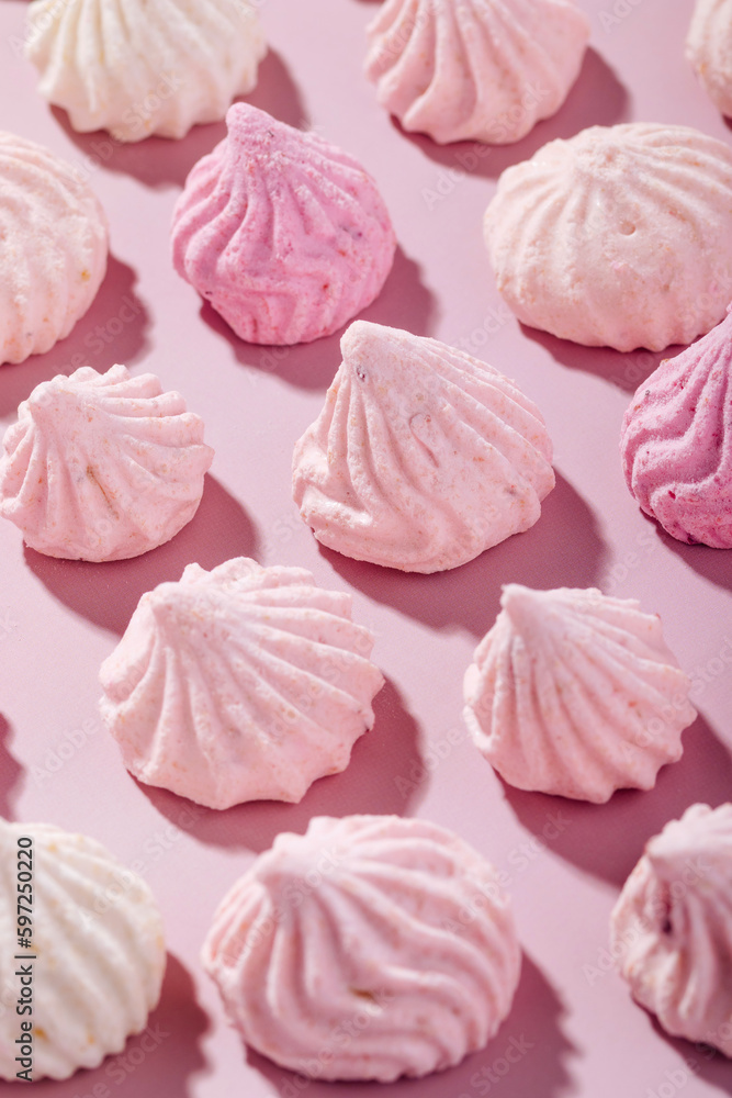Pink meringue cookies with berry flavor on a pink background Pink meringue cookies with berry flavor on a pink background