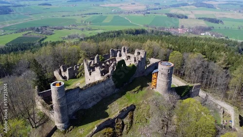 Aerial shot of the castle in the middle of the woods. A ruined castle located on a hill in the middle of the woods. Medieval castle tower