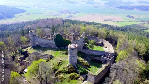 Aerial shot of the castle in the middle of the woods. A ruined castle located on a hill in the middle of the woods. Medieval castle tower