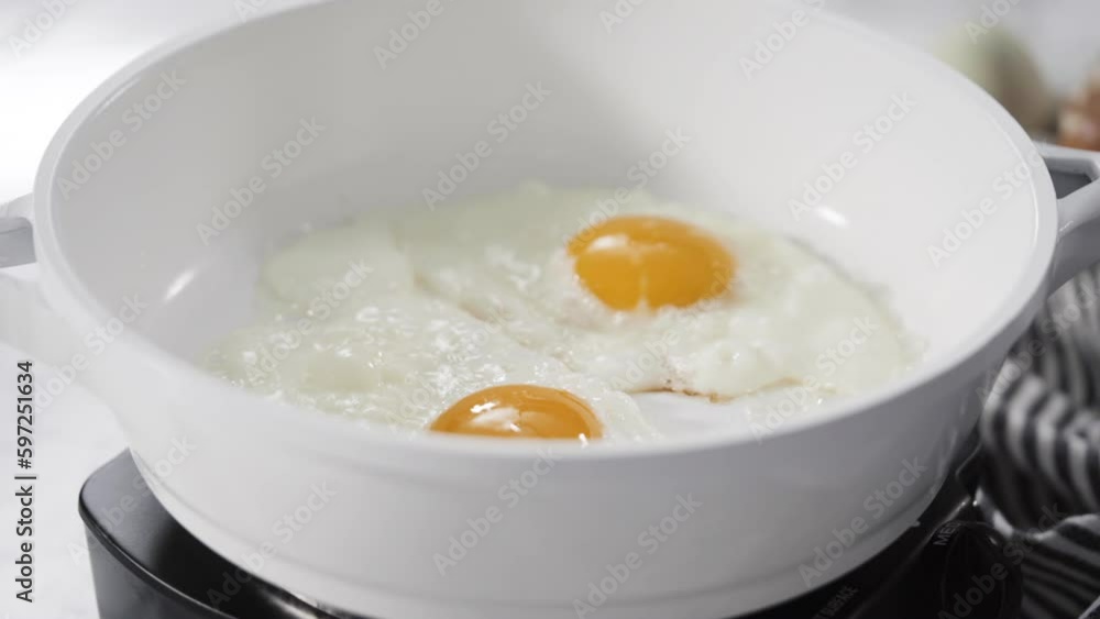 Close up view. Frying farm fresh eggs in a white skillet. Close up view. Frying farm fresh eggs in a white skillet.
