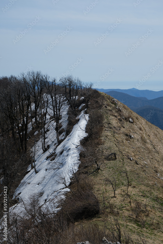 Snow on ridge on one side of cliff because of shade in early spring. Landscape and beautiful untouched nature. Mount Peus in Tuapse district in southern Russia. Snow on ridge on one side of cliff because of shade in early spring. Landscape and beautiful untouched nature. Mount Peus in Tuapse district in southern Russia.
