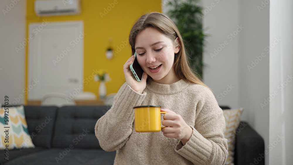 Young blonde woman talking on smartphone drinking coffee at home Young blonde woman talking on smartphone drinking coffee at home