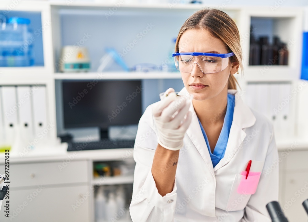 Young hispanic woman scientist looking sample at laboratory Young hispanic woman scientist looking sample at laboratory