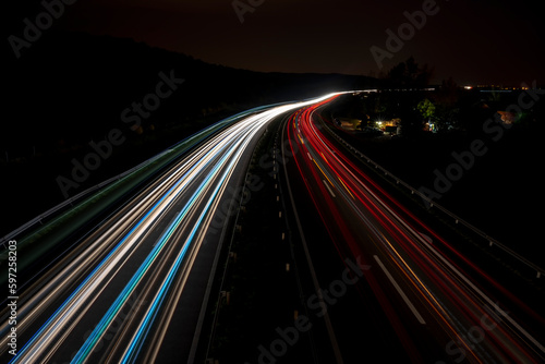 Cars light trails on a straight highway at sunset. Night traffic trails, Motion blur, Night city road with traffic headlight motion. 
