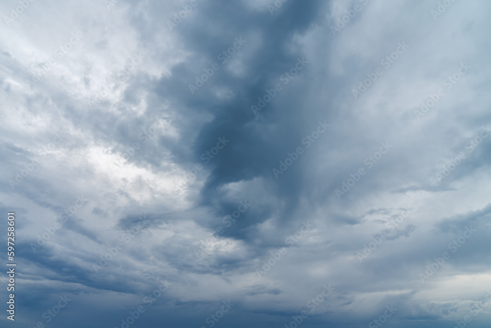Close up photograph of turbulent looking storm clouds moving in the sky at sunset with dark blue shadows and texture isolated for sky replacement.