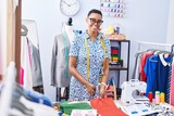 African american woman tailor smiling confident cutting cloth at tailor shop