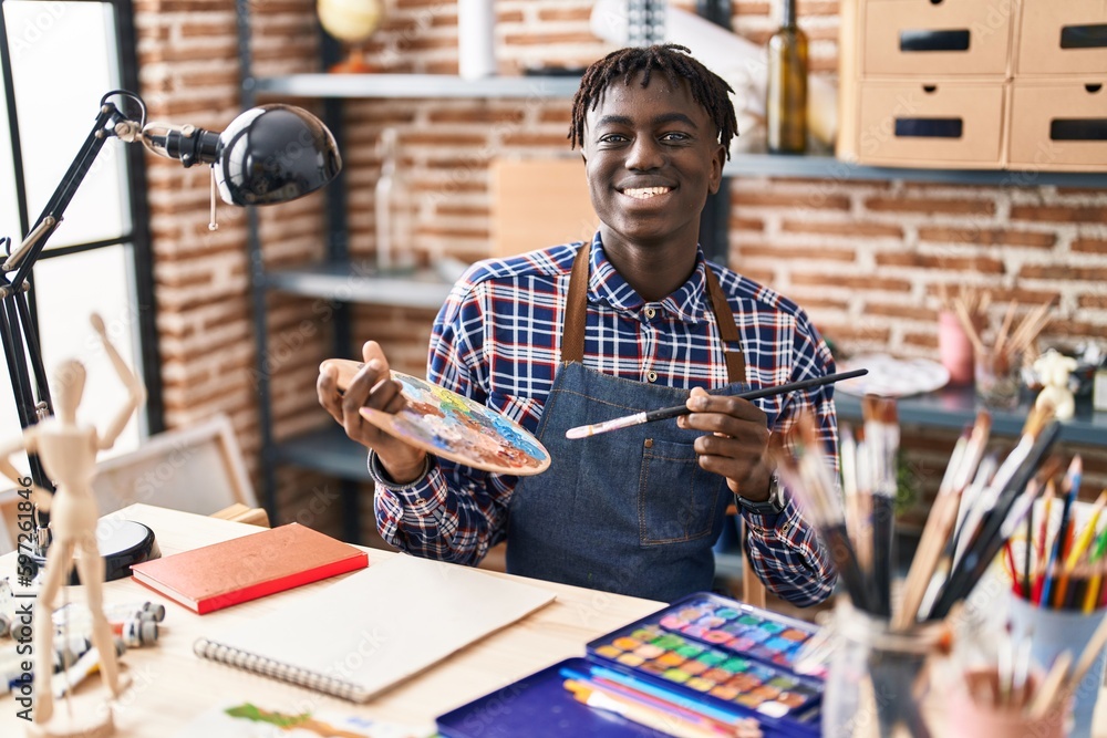 Fototapeta premium African american man artist smiling confident drawing on notebook at art studio