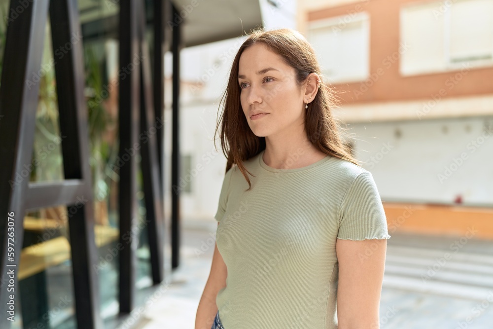 Young beautiful woman looking to the side with serious expression at street Young beautiful woman looking to the side with serious expression at street