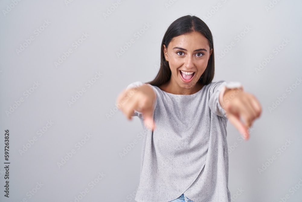Young hispanic woman standing over white background pointing to you and the camera with fingers, smiling positive and cheerful Young hispanic woman standing over white background pointing to you and the camera with fingers, smiling positive and cheerful