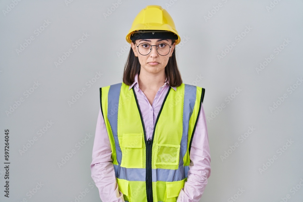 Hispanic girl wearing builder uniform and hardhat depressed and worry for distress, crying angry and afraid. sad expression. Hispanic girl wearing builder uniform and hardhat depressed and worry for distress, crying angry and afraid. sad expression.