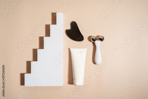 A face metal massager made of steal and a white tube of cream, product line presentation, marketing and branding