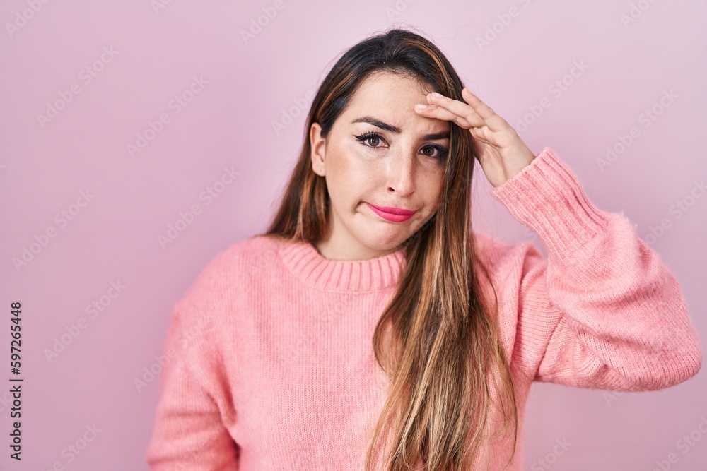 Young hispanic woman standing over pink background worried and stressed about a problem with hand on forehead, nervous and anxious for crisis Young hispanic woman standing over pink background worried and stressed about a problem with hand on forehead, nervous and anxious for crisis