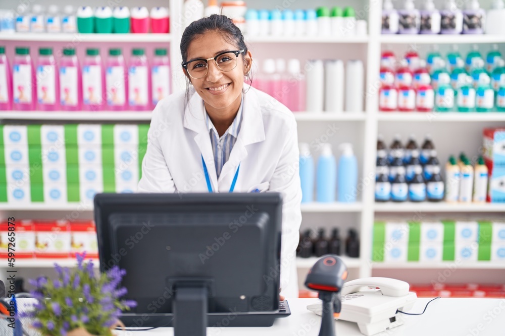 Young beautiful hispanic woman pharmacist smiling confident using computer at pharmacy Young beautiful hispanic woman pharmacist smiling confident using computer at pharmacy