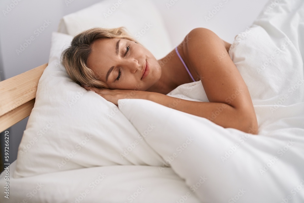 Young blonde woman lying on bed sleeping at bedroom Young blonde woman lying on bed sleeping at bedroom
