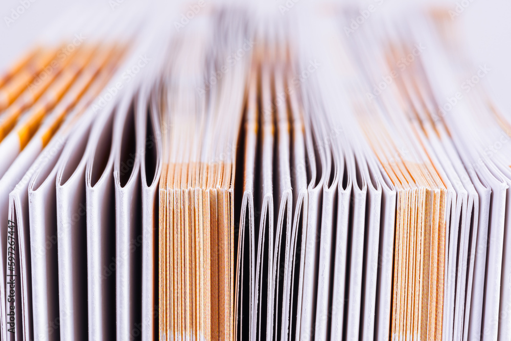 Edge of a file of paper advertising brochures with a blurred background Edge of a file of paper advertising brochures with a blurred background