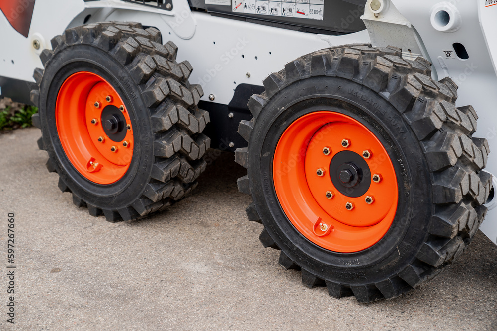 Construction loader big fresh new wheels with warning orange disks. Construction vehicle wheels Construction loader big fresh new wheels with warning orange disks. Construction vehicle wheels