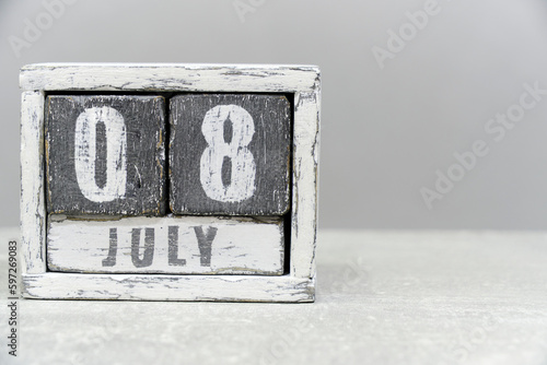 Calendar for July 08, made of wooden cubes, on gray background.With an empty space for your text.