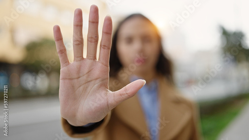 Young beautiful hispanic woman doing stop gesture with hand at street © Krakenimages.com