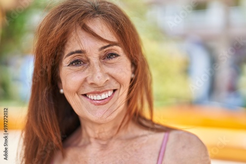 Middle age woman smiling confident standing at park