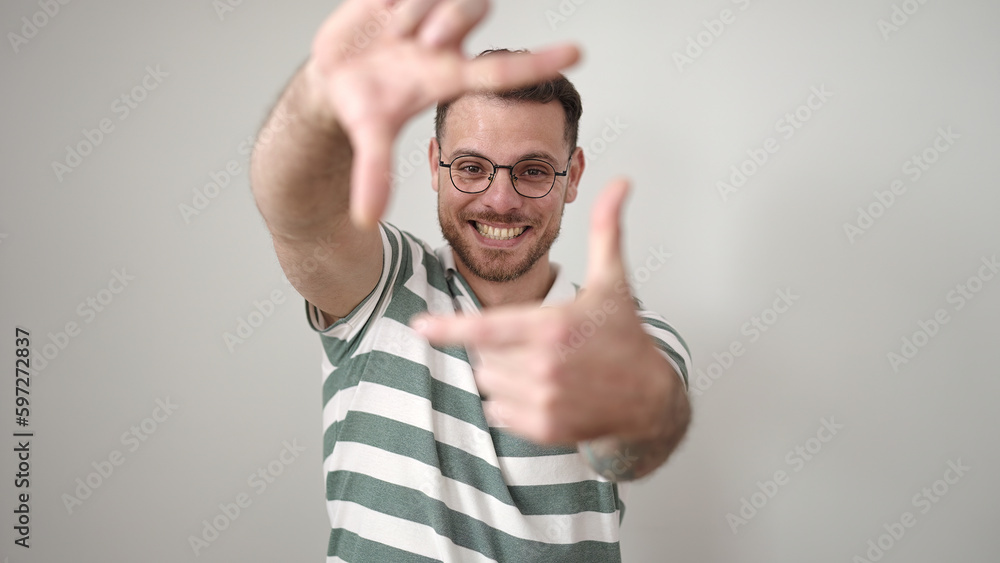 Young caucasian man smiling confident doing frame gesture with hands over isolated white background Young caucasian man smiling confident doing frame gesture with hands over isolated white background