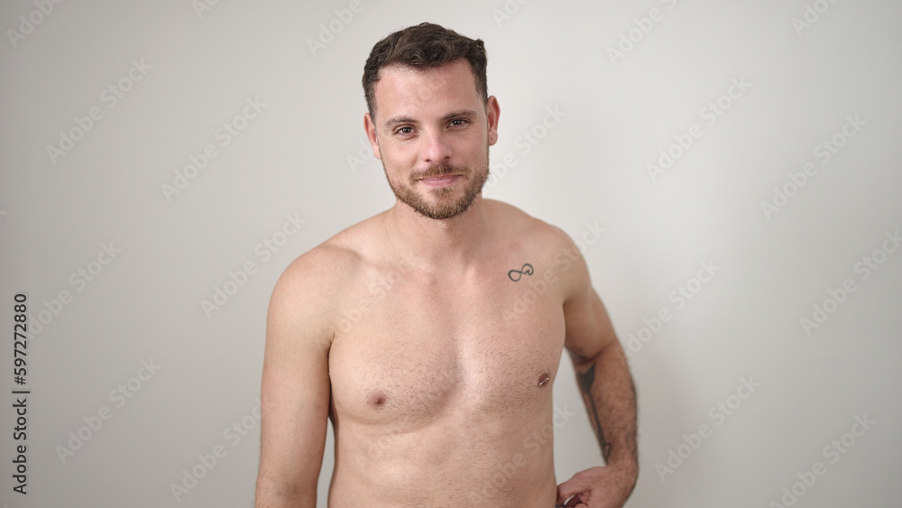 Young caucasian man standing shirtless with serious expression over isolated white background