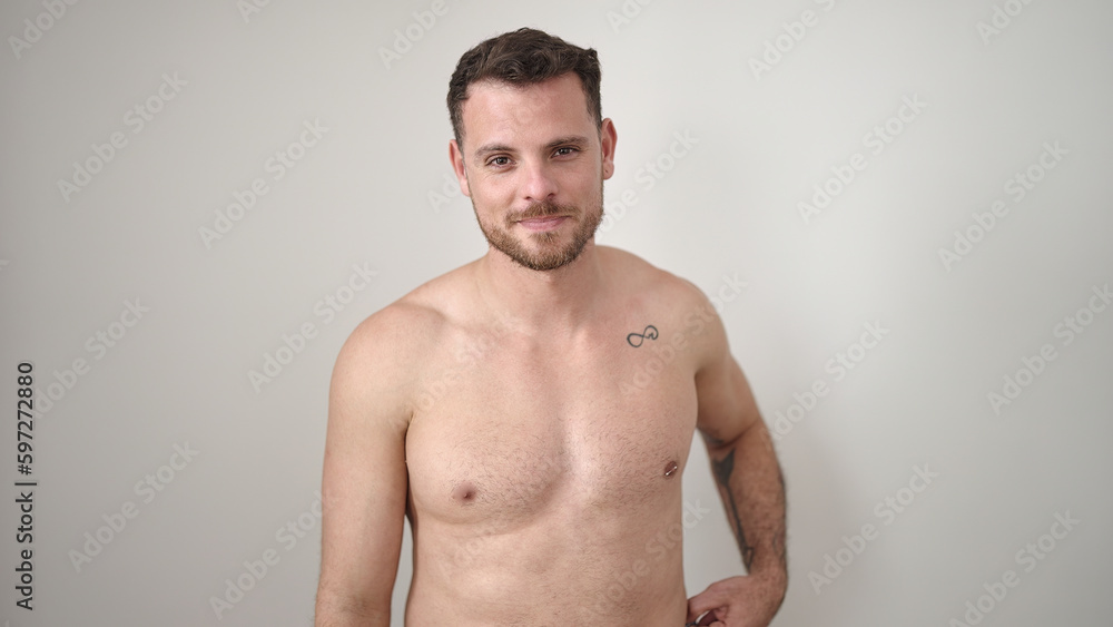 Fototapeta premium Young caucasian man standing shirtless with serious expression over isolated white background