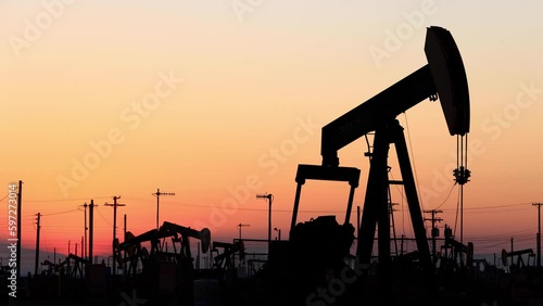 The sun rises behind oil pumps in California