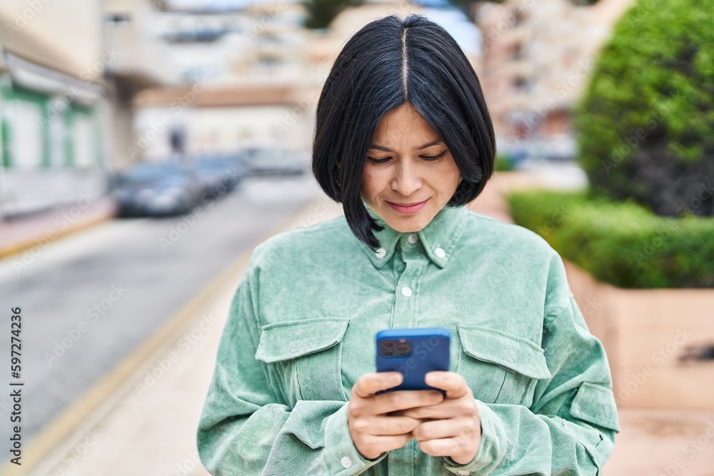 Young chinese woman smiling confident using smartphone at street Young chinese woman smiling confident using smartphone at street