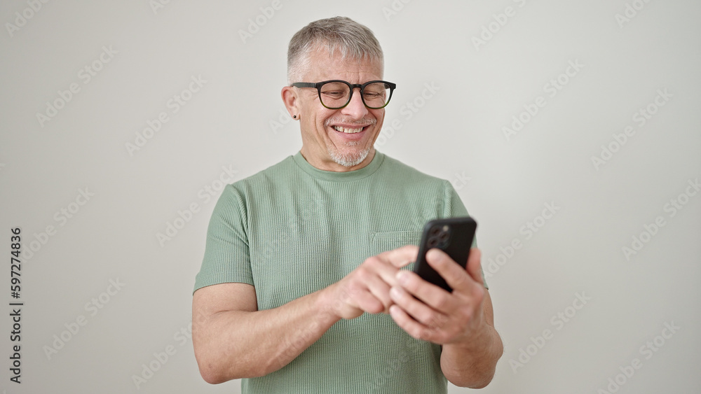 Middle age grey-haired man smiling confident using smartphone over isolated white background Middle age grey-haired man smiling confident using smartphone over isolated white background