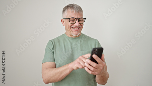 Middle age grey-haired man smiling confident using smartphone over isolated white background