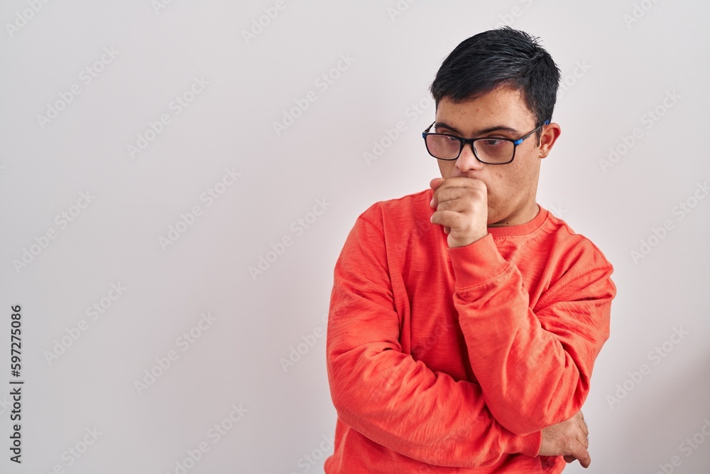 Young hispanic man with down syndrome standing over white background feeling unwell and coughing as symptom for cold or bronchitis. health care concept. Young hispanic man with down syndrome standing over white background feeling unwell and coughing as symptom for cold or bronchitis. health care concept.