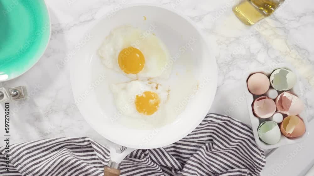 Flat lay. Frying farm fresh eggs in a white skillet. Flat lay. Frying farm fresh eggs in a white skillet.