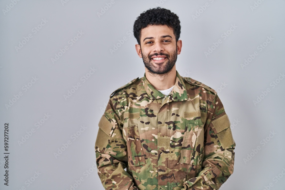 Arab man wearing camouflage army uniform with hands together and crossed fingers smiling relaxed and cheerful. success and optimistic Arab man wearing camouflage army uniform with hands together and crossed fingers smiling relaxed and cheerful. success and optimistic