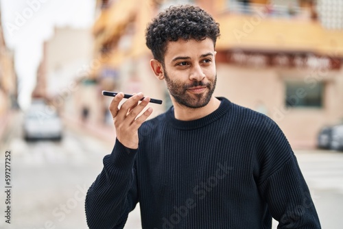 Young arab man smiling confident talking on the smartphone at street