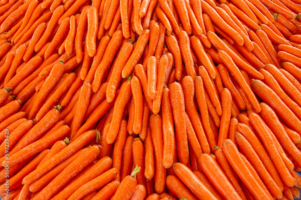 Orange bright shiny fresh carrots are laid out on the market counter, an attractive appetizing look. Orange bright shiny fresh carrots are laid out on the market counter, an attractive appetizing look.