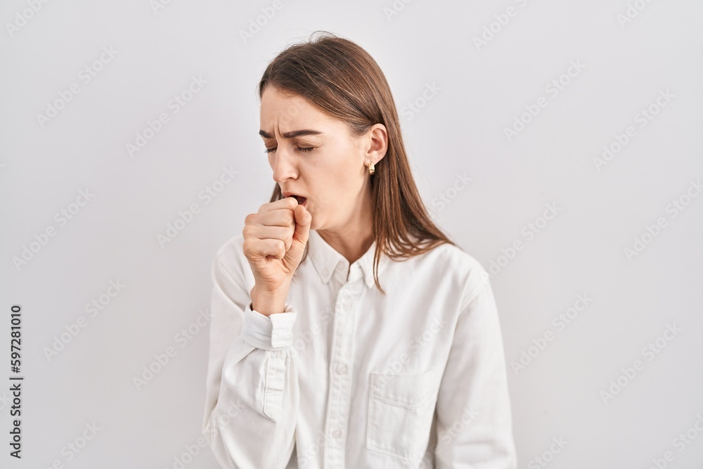 Young caucasian woman standing over isolated background feeling unwell and coughing as symptom for cold or bronchitis. health care concept. Young caucasian woman standing over isolated background feeling unwell and coughing as symptom for cold or bronchitis. health care concept.
