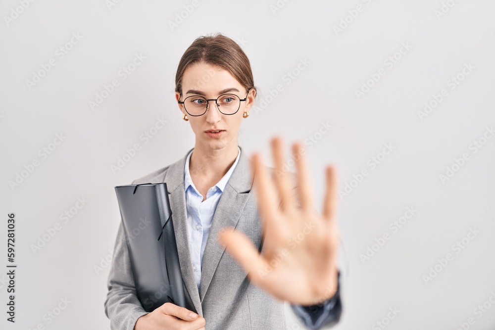 Young caucasian woman wearing business clothes and glasses doing stop gesture with hands palms, angry and frustration expression Young caucasian woman wearing business clothes and glasses doing stop gesture with hands palms, angry and frustration expression