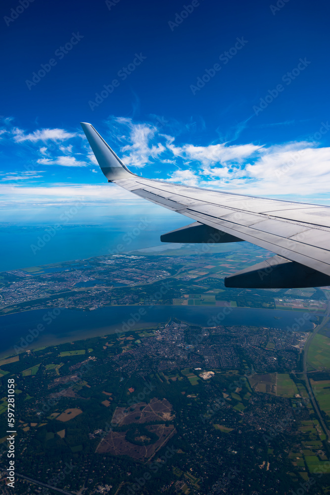 Obraz premium Boeing 737 wing. Flight over Amsterdam. blue sky with white clouds