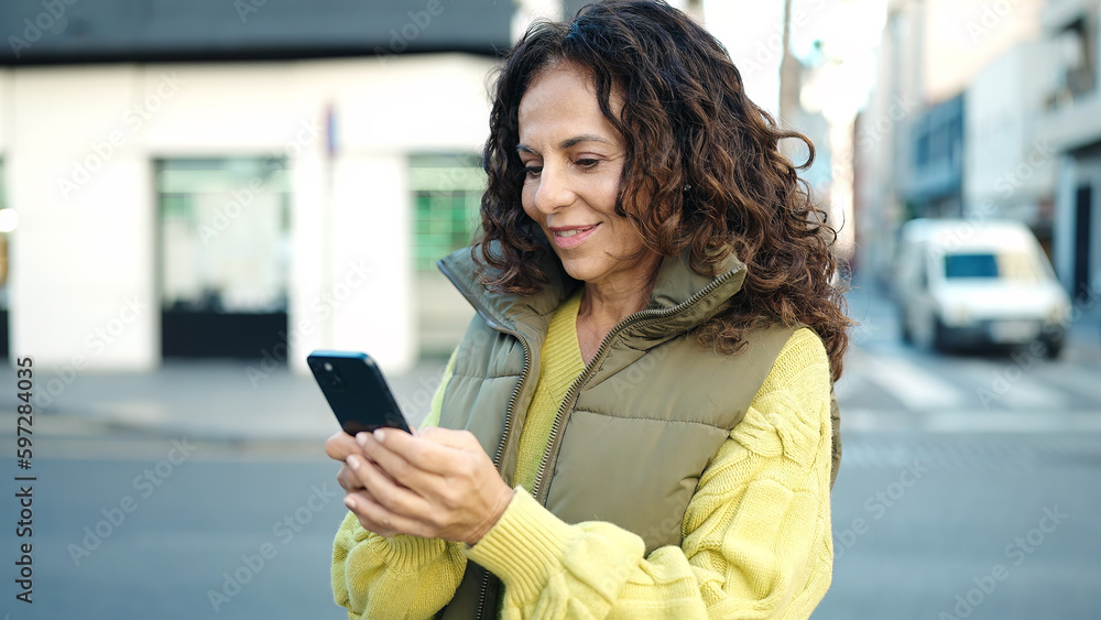 Middle age hispanic woman smiling confident using smartphone at street Middle age hispanic woman smiling confident using smartphone at street