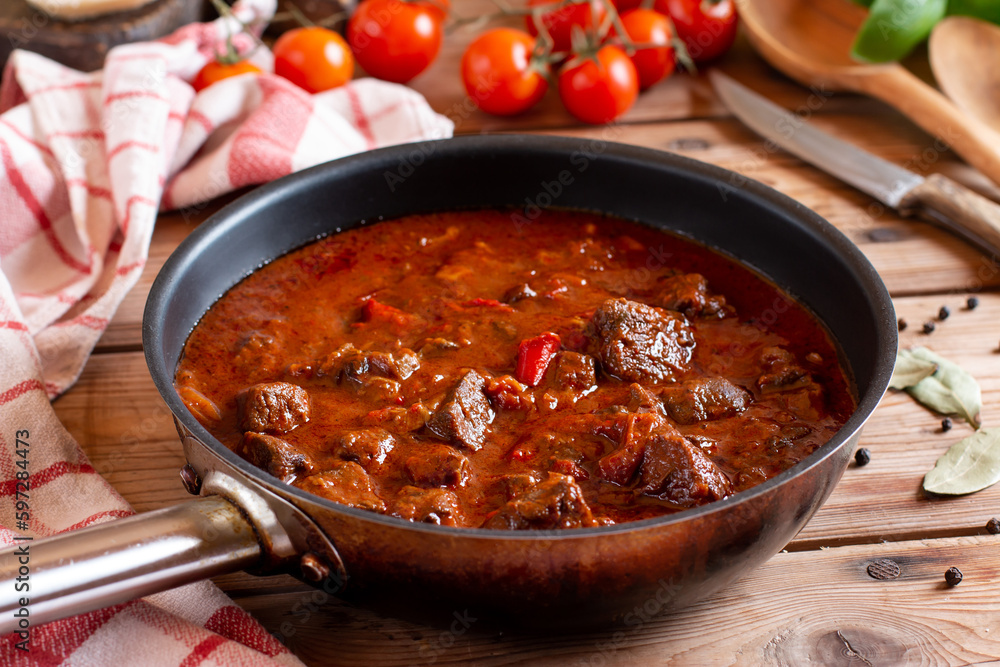 Classic Czech goulash in a frying pan, delicious heavy food on table Classic Czech goulash in a frying pan, delicious heavy food on table