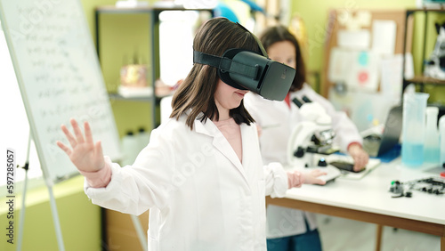 Adorable girls scientist student using virtual reality glasses at laboratory classroom